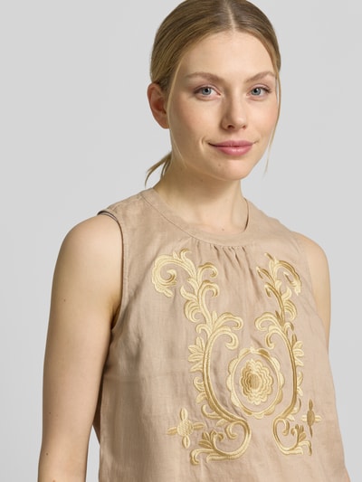 Frauenmodel trägt Blusentop aus Leinen mit Stitchings von Emily Van den Bergh in Beige mit Zierstickerei, Regular Fit, Nahaufnahme Oberkörper.