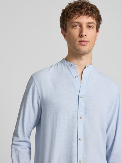 Männermodel trägt Regular Fit Freizeithemd aus Baumwoll-Leinen-Mix von Jack & Jones, hellblau, Stehkragen, Knopfleiste, Nahaufnahme Oberkörper.