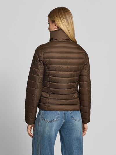 Modelka kobieca ma na sobie brązową kurtkę pikowaną o kroju regular fit ze stójką Regular Fit Steppjacke mit Stehkragen od Marc O'Polo, damska kurtka pikowana, widok całej sylwetki z tyłu.