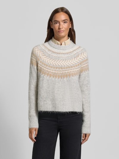 Frauenmodel trägt Pullover aus Alpaka Wolle mit Jacquardstruktur von Barbour, mehrfarbig, geometrisches Muster, Strickoptik, Ganzkörperansicht von vorne.