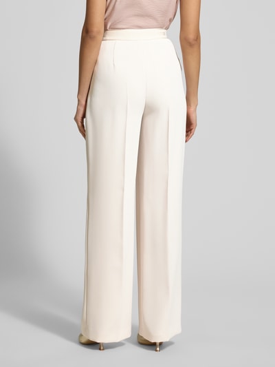 Frauenmodel trägt Hose mit Bügelfalten Modell 'WILLOW O' von Raffaello Rossi in Creme, Regular Fit, Eingrifftaschen, Ganzkörperansicht Rückansicht. Bundweite 40 cm, Innenbeinlänge 85 cm bei Größe 36.