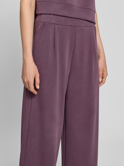 Kobiece model prezentuje spodnie dresowe Wide Leg Sweatpants mit Eingrifftaschen od Rich & Royal, mieszanka modalu z dodatkiem streczu, wpuszczane kieszenie, elastyczny pas, długość wewnętrzna nogawki w rozmiarze S: 64 cm, zbliżenie na górną część spodni