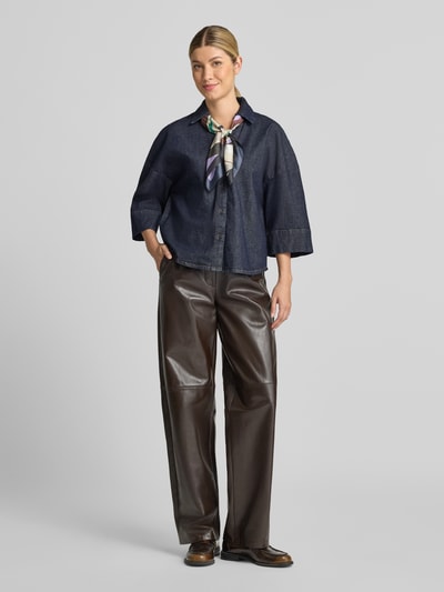 Frauenmodel trägt Relaxed Fit Jeansbluse aus Baumwoll-Mix von Tom Tailor in Dunkelblau zu weiter brauner Hose, Ganzkörperansicht von vorne. Damen Jeansbluse von Tom Tailor.