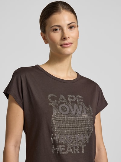 Frauenmodel trägt Regular Fit T-Shirt mit Statement-Print von monari, Baumwoll-Modal-Mix, Rundhalsausschnitt, kurzärmelig, Nahaufnahme Oberkörper.