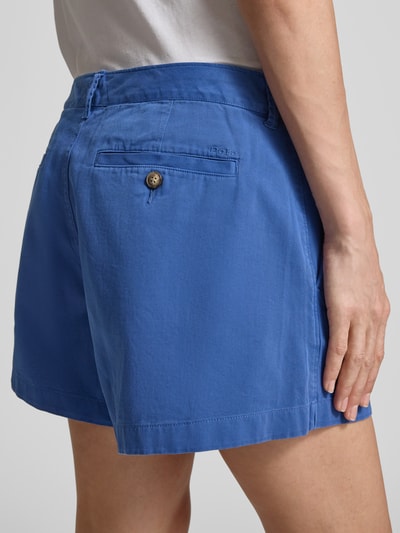 Frauenmodel trägt Loose Fit Bermudas aus reiner Baumwolle von Polo Ralph Lauren in Unifarbe Blau, Twillstruktur, Gesäßtaschen mit Knopf, Ganzkörperansicht Rückansicht.