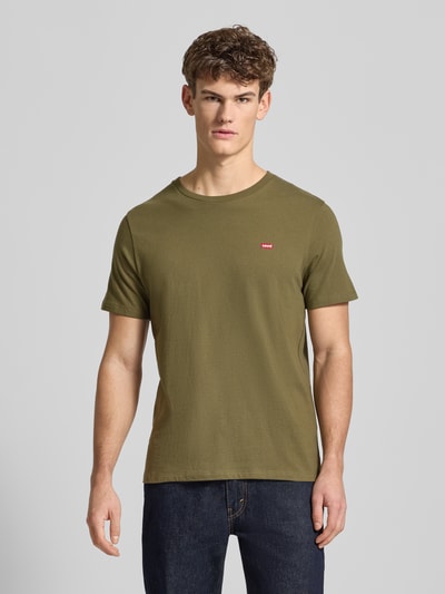 Männermodel trägt T-Shirt mit Label-Stitching von Levi's®, Herren T-Shirt aus reiner Baumwolle, Regular-Fit, olivgrün, Nahaufnahme Oberkörper.