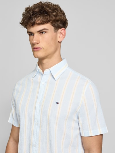 Männermodel trägt Regular Fit Freizeithemd aus Baumwoll-Mix von Tommy Jeans, Optik:Allover-Muster, Gestreift, Logo-Stitching, Nahaufnahme Oberkörper.