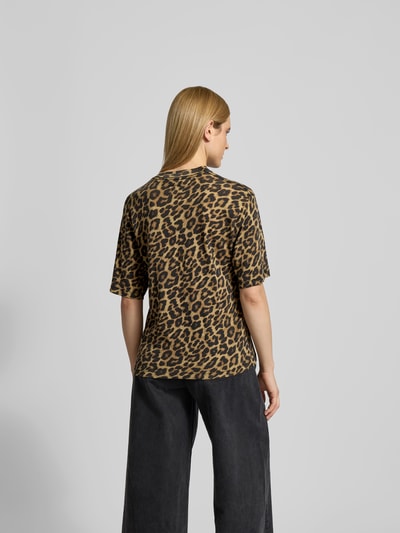 Frauenmodel trägt T-Shirt mit Allover-Animal-Print von Anine Bing aus reiner Baumwolle, Regular-Fit, Rundhalsausschnitt, Halbarm-Design, Rückenlänge bei Größe S 66 cm, Ganzkörperansicht Rückansicht.