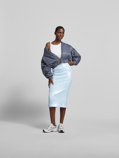 Frauenmodel trägt Midirock mit Allover-Pailettenbesatz von ROTATE aus Elastischer-Material-Mix in Hellblau, Slim-Fit, Nahtreißverschluss, Hakenverschluss, Ganzkörperansicht von vorne.