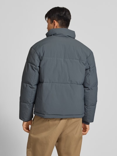 Männermodel trägt Steppjacke mit verdecktem Reißverschluss Modell 'SOHO' von JACK & JONES in Grau, Regular Fit, Ganzkörperansicht Rückansicht. Rückenlänge 70 cm, Schulterbreite 47 cm, Brustweite 60 cm, Ärmellänge 68 cm.