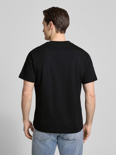 Männermodel trägt T-Shirt mit Rundhalsausschnitt von CK Calvin Klein, schwarze Farbe, Regular-Fit, reine Baumwolle, Rückenlänge 67 cm, Ganzkörperansicht Rückansicht.