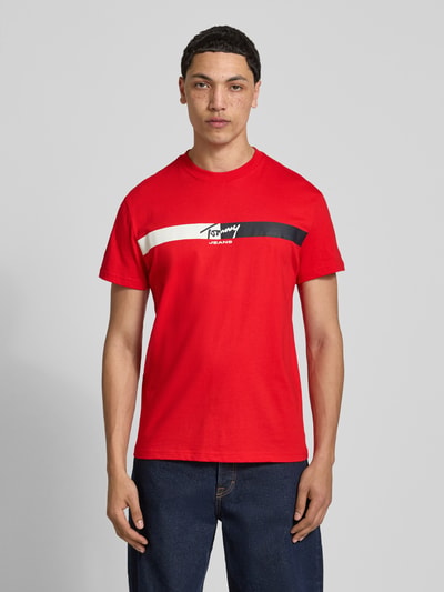 Männermodel trägt Regular Fit T-Shirt aus reiner Baumwolle von Tommy Jeans in Optik: Unifarben, mit Label-Print, Ganzkörperansicht von vorne.