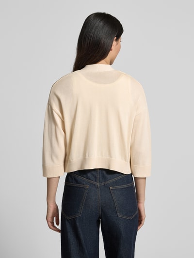 Frauenmodel trägt Strickjacke aus Lyocell-Baumwoll-Mix in offener Passform von comma, cremefarben, 3/4-Arm, Ganzkörperansicht Rückansicht.