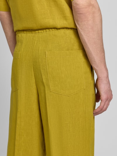 Männermodel trägt Relaxed Fit Leinenhose aus reinen Leinen von JAKE*S STUDIO MEN in Senfgelb, sichtbare Gesäßtaschen, Detailaufnahme, Kontext: reines Leinen, elastischer Bund mit Tunnelzug, Eingriff- und Gesäßtaschen, semitransparentes Design, Größe M Maße