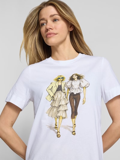 Modelka kobieca nosi T-Shirt mit Motiv-Print und Strasssteinbesatz od Rich & Royal z czystej bawełny organicznej, krój straight fit, okrągły dekolt, kolor biały, nadruk z przodu, detal z dżetami, długość pleców 58 cm w rozmiarze S, zdjęcie: zbliżenie na górną część ciała.