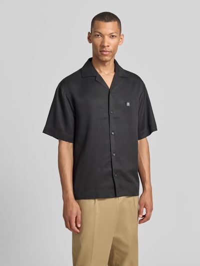 Männermodel trägt Relaxed Fit Freizeithemd aus reinem Lyocell Modell 'ESPINO' von HUGO, schwarz, Resortkragen, Nahaufnahme Oberkörper.