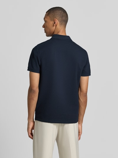 Männermodel trägt Regular Fit Poloshirt mit Strukturmuster von MCNEAL in Dunkelblau, Baumwoll-Mix, Reißverschluss, Kurzärmelig, Ganzkörperansicht Rückansicht.