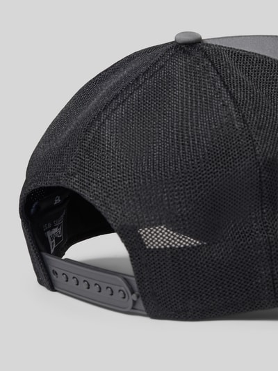 Produktfoto, Trucker Cap mit verstellbarem Riegel auf der Rückseite von New Era, schwarzes Mesh hinten, verstärkter Schirm, Steppnähte, Statement-Applikation, verstellbarer Riegel, tył z siateczki