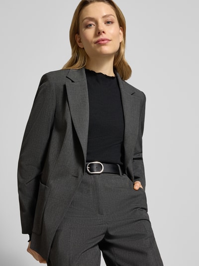 Kobiece modelka nosi Slim Fit Langarmshirt mit Viskose-Anteil von s.Oliver RED LABEL, czarny, prążkowana faktura, krój slim fit, wysoki dekolt, długie rękawy z falbanką, wykończenie u dołu z falbanką, widok z przodu, ujęcie do pasa.