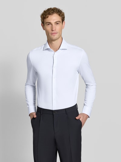 Männermodel trägt weißes Slim Fit Businesshemd mit Strukturmuster von Seidensticker, dezenter Glanz, Ganzkörperansicht von vorne. Herren Businesshemd von Seidensticker.