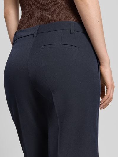 Frauenmodel trägt Hose mit Bügelfalten und Gesäßtasche von Christian Berg Woman Selection, Material-Mix mit Viskose-Anteil, Regular-Fit, Dunkelblau, Detailaufnahme Rückansicht.