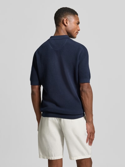 Męski model nosi Regular Fit Poloshirt mit Label-Stitching od Gant, granatowa bawełna, kołnierzyk polo, krój regular fit, długość tyłu w rozmiarze M 68 cm, całkowity widok z tyłu