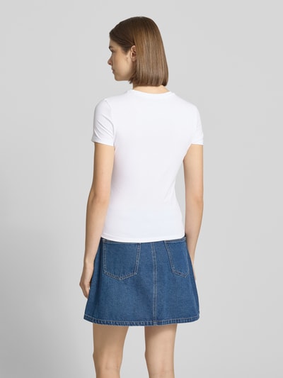 Frauenmodel trägt Slim Fit T-Shirt mit Motiv-Print und Rundhalsausschnitt von REVIEW in Weiß, kombiniert mit Jeansrock, Baumwoll-Elasthan-Mix, Rückansicht Ganzkörperansicht.