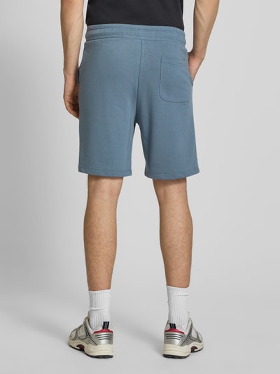 Mężczyznamodel nosi Sweatshorts mit Logo Model 'KANE' von Jack & Jones w kolorze niebieskim, bawełniany melanż, krój relaxed fit, elastyczny pas, widoczne logo, szerokość w rozmiarze M: 42 cm, długość nogawki od wewnątrz: 19 cm, widok całej sylwetki z tyłu.