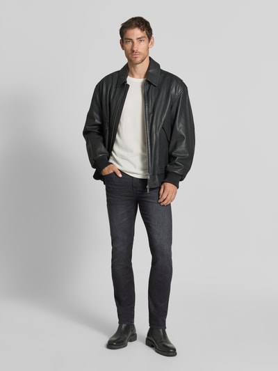 Männermodel trägt Slim Fit Jeans aus Baumwoll-Mix Modell 'Delaware' von BOSS in dunklem Blau, dezente Struktur, Ganzkörperansicht von vorne, Kontext: Herren Straight Fit Jeans von BOSS.