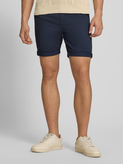 Mężczyzna nosi Regular Fit Shorts mit Münztasche von Superdry, granatowe, mieszanka bawełny, kieszonka na monety, kieszeń z tyłu, zapięcie na guzik i zamek błyskawiczny, szerokość w rozmiarze 32: 44 cm, długość wewnętrzna nogawki w rozmiarze 32: 20 cm, krój regular fit, widok na całe ciało z przodu.