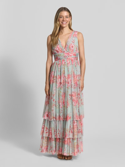 Frauenmodel trägt Abendkleid mit Volantsaum und V-Ausschnitt von LACE & BEADS aus geblühmtem Chiffon, A-Linie, Maxikleid, Ganzkörperansicht von vorne.