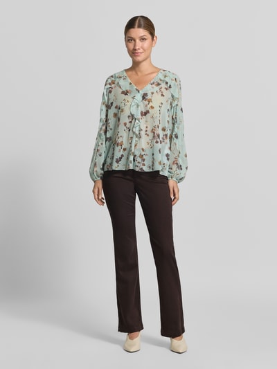 Frauenmodel trägt Flared Fit Jeans mit Lyocell-Anteil von Marc Cain in Dunkelbraun aus elastischem Material-Mix, Ganzkörperansicht von vorne.