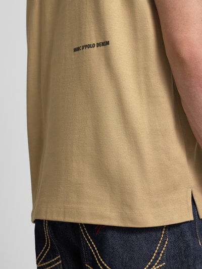 Männermodel trägt Boxy Fit Freizeithemd aus reiner Baumwolle von Marc O'Polo Denim in Beige, strukturierte Heavy Jersey-Optik, Nahaufnahme Oberkörper.