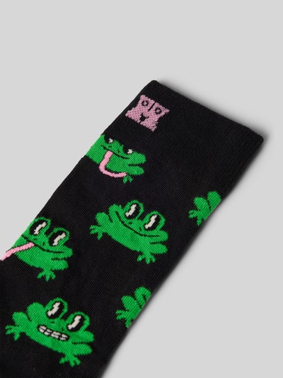 Produktfoto, Socken aus Baumwoll-Mix Modell 'Frog' von Happy Socks, schwarze Basis mit grünen Froschmotiven, feine Rippenstruktur.