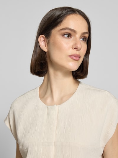 Frauenmodel trägt Bluse aus Viskose-Mix mit Eingrifftaschen Modell 'Wenali' von OPUS PANTS, Rundhalsausschnitt, Kappärmel, Nahaufnahme Oberkörper.