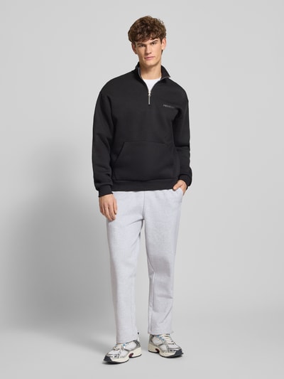 Männermodel trägt Regular Fit Sweatpants mit elastischem Bund Modell 'Source' von BLKVIS aus reiner Baumwolle in Hellgrau, Ganzkörperansicht von vorne.