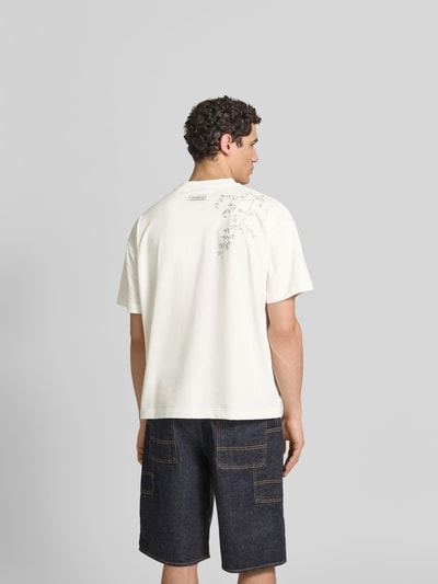 Männermodel trägt Relaxed Fit T-Shirt aus Baumwoll-Mix von Don’t Waste Culture in Weiß mit Motiv-Print und Label-Print, Rückenlänge 70 cm, Ganzkörperansicht Rückansicht.