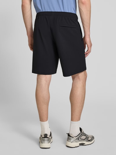 Männermodel trägt Regular Fit Sport-Shorts mit Label Print Modell 'TREVOL' von BOSS Green, Schwarz, elastischer Bund, Rückansicht Ganzkörperansicht.