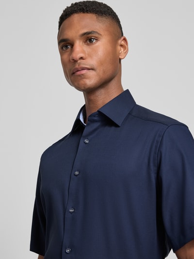 Männermodel trägt Regular Fit Business-Hemd mit Kentkragen von OLYMP, reine Baumwolle, dunkelblau, unifarben, Nahaufnahme Oberkörper.
