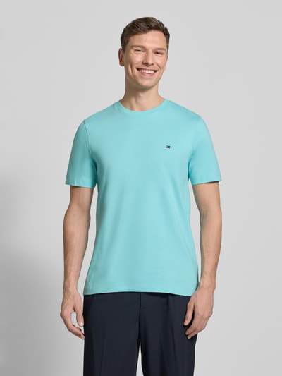 Männermodel trägt Regular Fit T-Shirt aus reiner Baumwolle von Tommy Hilfiger, Optik: Unifarben, Logo-Stitching, Rundhals, Jersey, Ganzkörperansicht von vorne.