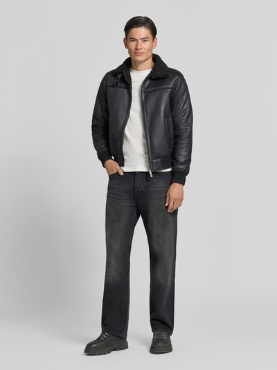 Männermodel trägt Regular Fit Jacke in Leder-Optik Modell 'Aviator' von MARKUP, Schwarz, Kunstfellbesatz, Stehkragen, Ganzkörperansicht von vorne.