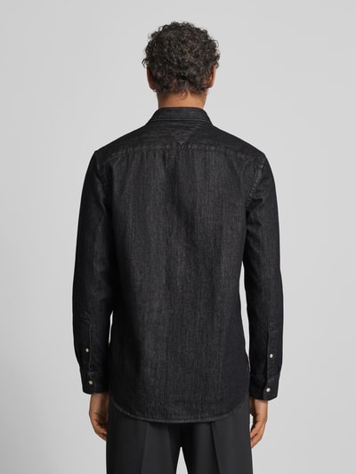 Männermodel trägt Regular Fit Jeanshemd aus reiner Baumwolle von Tommy Hilfiger in Black Denim mit Rückenpasse, Ganzkörperansicht Rückansicht.