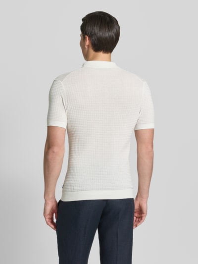 Männermodel trägt Slim Fit Poloshirt in Strick-Optik Modell 'Vanceo' von JOOP! Collection, reine Baumwolle, kurzärmelig, Rückansicht.