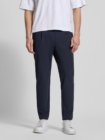 Männermodel trägt Slim Fit Hose mit Paspeltaschen am Gesäß von CRUNA in Dunkelblau, Material-Mix mit Stretch-Anteil, Eingrifftaschen, Ganzkörperansicht von vorne.