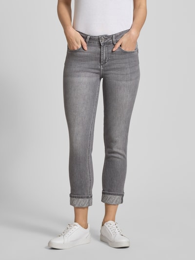 Kobiece model prezentuje Jeans z kieszeniami bocznymi model 'MONROE' od Liu Jo White, szary denim, krój skinny, ujęcie całej sylwetki z przodu.