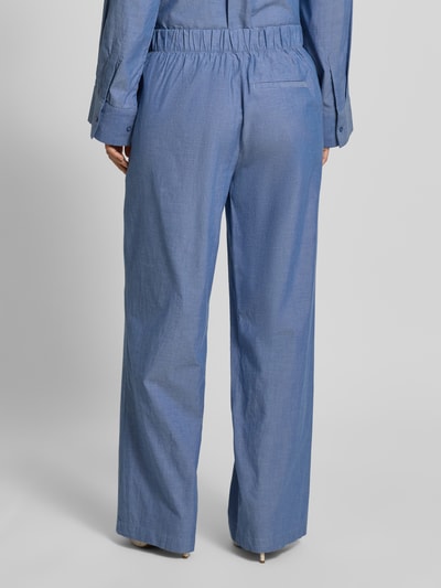 Männermodel trägt Regular Fit Weite Hose aus reiner Baumwolle Modell 'KIRA-TARA' von Selected Femme, melange Optik, popelina, z gumką w pasie, boczne kieszenie, Ganzkörperansicht Rückansicht.