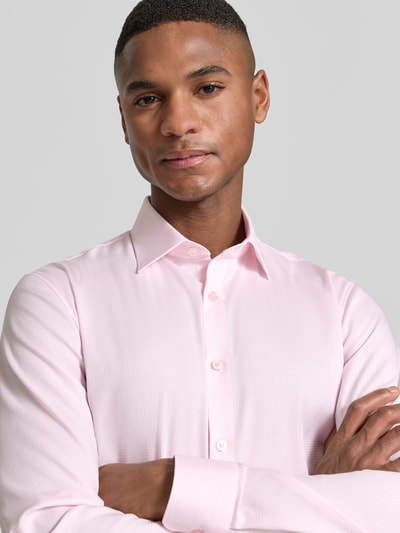 Männermodel trägt Slim Fit Businesshemd mit Kentkragen von OLYMP No. Six, elastischer Baumwoll-Mix, rosa, Nahaufnahme Oberkörper.