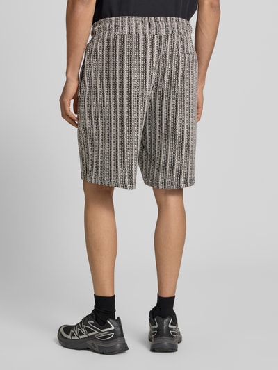 Männermodel trägt Straight Fit Shorts mit Strukturmuster Modell 'Forno' von Pegador aus Reine Baumwolle, Ganzkörperansicht Rückansicht.
