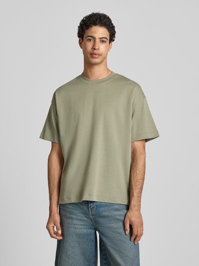 Mannelijk model draagt T-shirt met ronde hals model 'BARRON' van Jack & Jones, katoenmix met stretch, regular fit, grijs, voorkant, halve lichaamsopname.