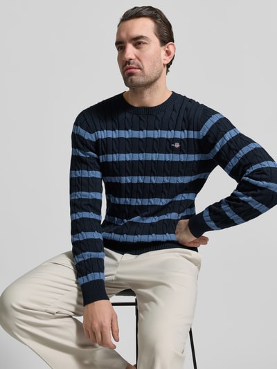 Männermodel trägt Slim Fit Pullover in Strick-Optik von Gant, reine Baumwolle, Rundhalsausschnitt, marineblau mit blauen Streifen, Nahaufnahme Oberkörper.